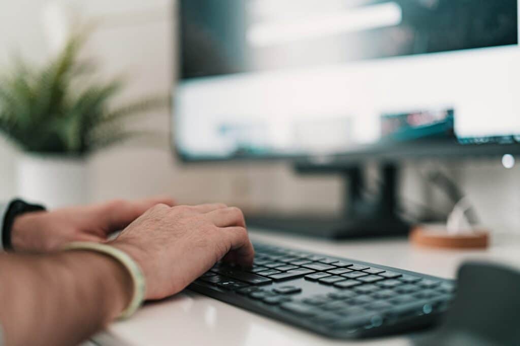 man typing on a keyboard - Multi Factor Authentication in Banking